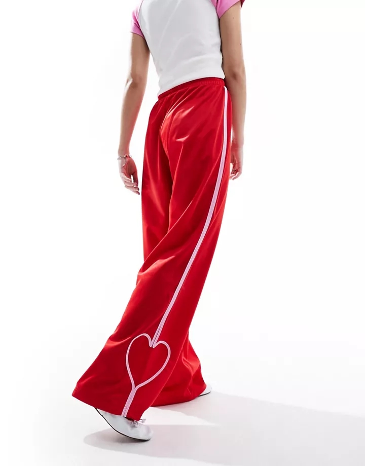 Pantalones de chándal rojos de pernera recta con banda lateral rosa y detalle de corazón de Monki Rojo y rosa h9MG4WxS