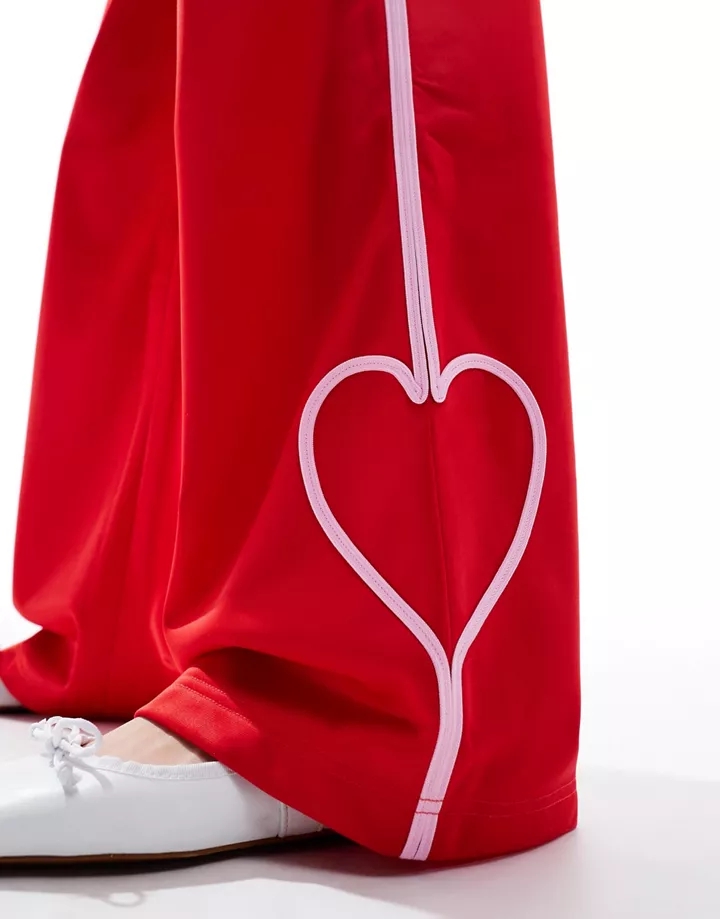 Pantalones de chándal rojos de pernera recta con banda lateral rosa y detalle de corazón de Monki Rojo y rosa h9MG4WxS